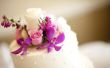 Het rangschikken van verse bloemen op een bruiloft-taart