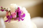 Het rangschikken van verse bloemen op een bruiloft-taart
